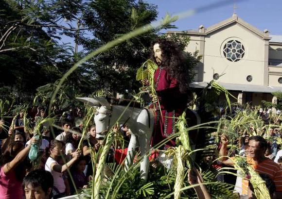 Reuters - Cat&#243;licos rodean una estatua de Cristo al participar en una procesi&#243;n durante la celebraci&#243;n de Domingo de Ramos frente a la Catedral Metropolitana de Asunci&#243;n en Paraguay.