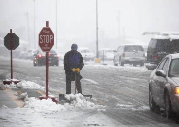 Reuters - Neal Abernathy, un empleado con el Centro de Ahorro Familiar en Mountain View Road en Rapid City, saca la nieve a la entrada de la tienda luego de la tormenta que cay&#243; en Dakota del Sur.
