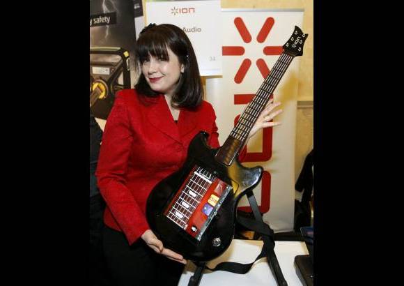 Reuters - 1. La gerente de productos de Ion, Wendy Mittelstadt, muestra este control para la tableta iPad, de Apple, en forma de guitarra, que promete convertirlo en un mago del instrumento.