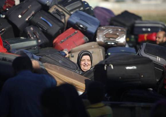 Reuters - Una pasajera palestina, busca su maleta, con la esperanza de cruzar a Egipto.