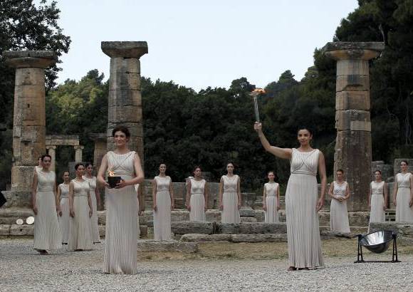 Foto Reuters - Despu&#233;s de la tradicional danza de las ninfas y la ceremonia marcial, sin armas, de los hombres, la gran sacerdotisa entreg&#243; la antorcha a su primer portador, el campe&#243;n ol&#237;mpico de nataci&#243;n en mar Spyros Yanniotis, qui&#233;n despu&#233;s la ofreci&#243; al joven boxeador Alexandro Lukos, un brit&#225;nico de origen griego de 19 a&#241;os.