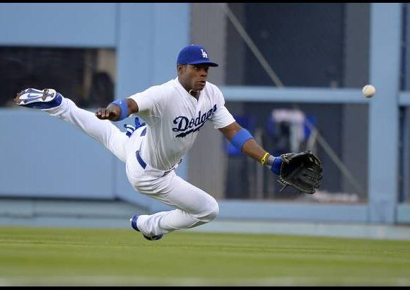AP - El jardinero derecho de Los &#193;ngeles Dodgers Yasiel Puig trata de agarrar la pelota en pleno partido contra los Yankees de Nueva York.