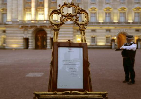 AP - Un aviso que anuncia el nacimiento del bebé del príncipe Guillermo y Kate, duquesa de Cambridge se expone a la vista del público en el Palacio de Buckingham en Londres.