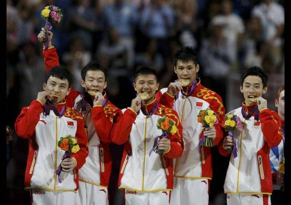 Reuters - De izquierda a derecha los gimnastas chinos, Guo Weiyang, Chen Yibing, Zhang Chenglong y Zou Kai, celebran la medalla dorada.