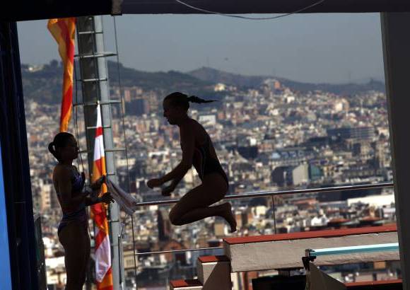 AP - Tania Cagnotto, de Italia, realiza ejercicios de calentamiento antes de participar en el trampolín de 3 metros en el Campeonato Mundial de Natación FINA en Barcelona.