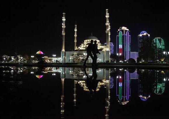 AP - La gente camina en el centro de Grozny, capital de Chechenia, al sur de Rusia, la Mezquita Central se refleja en el agua.