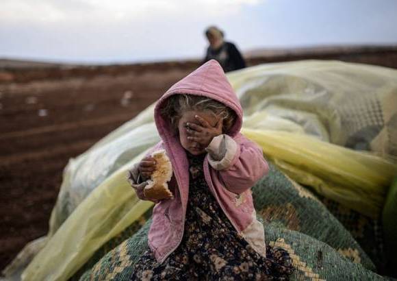 AFP - Una mujer kurda siria espera con su hija cerca de la frontera de Siria. Es el drama de los desplazados del conflicto.
