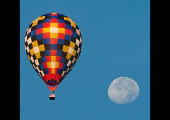 AP - Un globo de aire caliente vuela con la luna como telón de fondo durante la competencia del Campeonato Nacional de Estados Unidos, Hot Air Balloon.