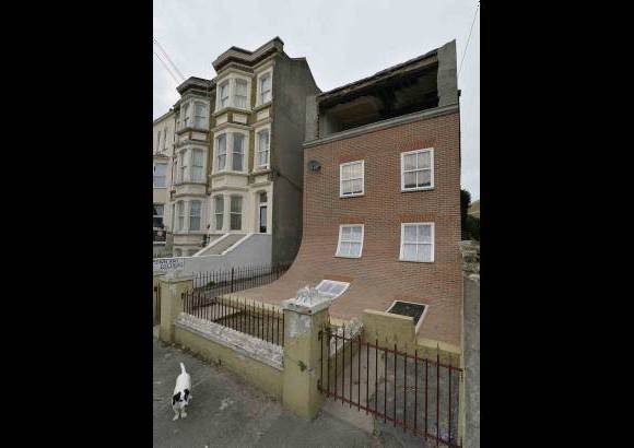RE - Un perro permanece al lado de una pieza de arte realizada en la zona residencial en Margate, Inglaterra. La escultura fue creada por el artista Alex Chinneck y estar&#225; expuesta por un a&#241;o.