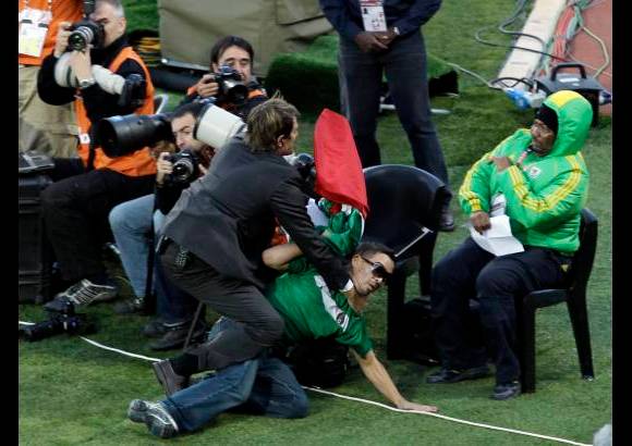 AP - Un agente de seguridad interviene a un aficionado que ingreso sin autorizaci&#243;n al terreno de juego.