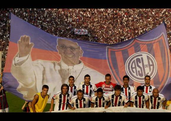 AP - El equipo de fútbol San Lorenzo de Almagro posó delante de una pancarta con una foto del Papa Francisco y los colores del club antes del partido contra Newell por la Liga argentina.
