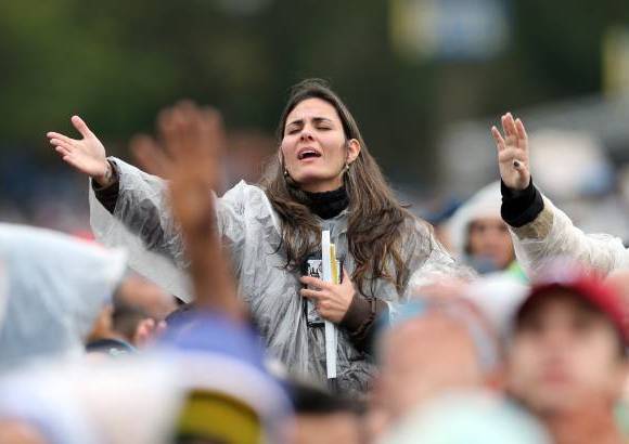 AP - Una mujer reza durante una misa celebrada por el Papa Francisco fuera de la Basílica de Aparecida, en Aparecida, Brasil.