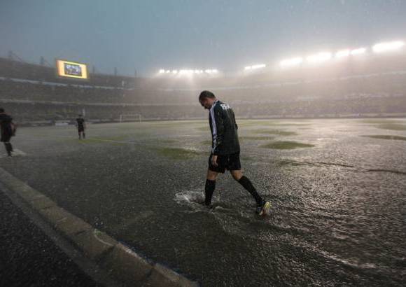 Reuters - Un juez Fifa revisa el campo de juego previo al partido de eliminatorias suramericanas para el Mundial Brasil 2014, entre Colombia y Brasil. El juego fue aplazado varias horas luego de que un fuerte aguacero cayera sobre Barranquilla.
