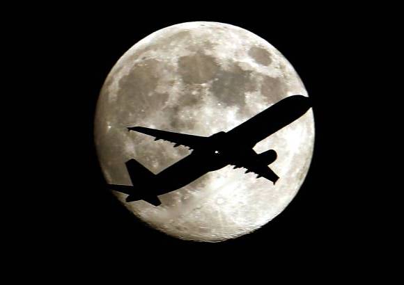 AP - Un jet se acerca al Aeropuerto Internacional de Los Angeles mostrando un bello contraste con la luna llena de esta semana.