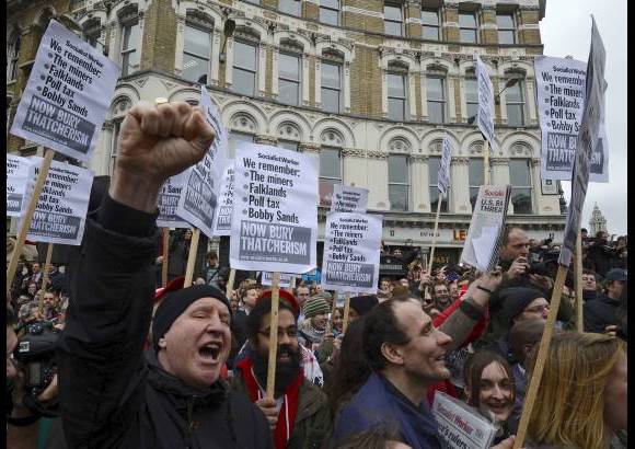 Reuters - Los manifestantes se burlan del el cortejo fúnebre de Margaret Thatcher.