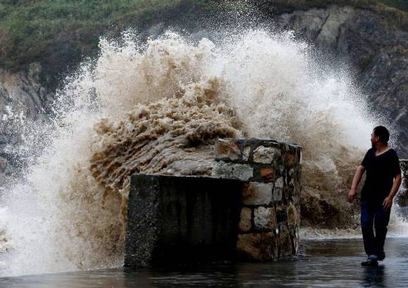 Reuters - Un hombre mira a una creciente ola en Wenling, provincia de Zhejiang. Trami, es el tif&#243;n n&#250;mero 12 que afecta a China este a&#241;o y sacudi&#243; la provincia de Fujian, este del pa&#237;s.
