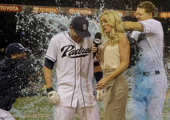 AP - El jugador de los padres de San Diego Chris Denorfia recibe el ba&#241;o de la victoria de Nick Hundley, a la derecha, y Ren&#233; Rivera mientras era entrevistado por Kelly Crull.