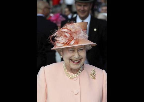 FOTO REUTERS - A pesar de unas temperaturas que alcanzaron los 24 grados, Isabel II luc&#237;a un conjunto de vestido y abrigo color melocot&#243;n con un sombrero a juego en la que fue la primera de las conocidas como &quot;fiestas del jard&#237;n&quot;.