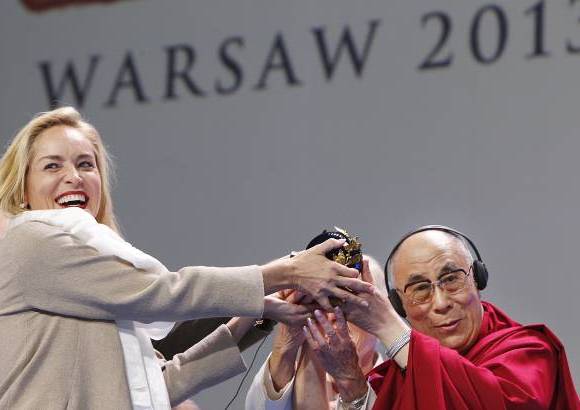 AP - La actriz Sharon Stone fue honrada por su trabajo para combatir el VIH y el sida en la ceremonia donde se reunieron los ganadores del Premio Nobel de Paz, en la imagen con Dalai Lama.
