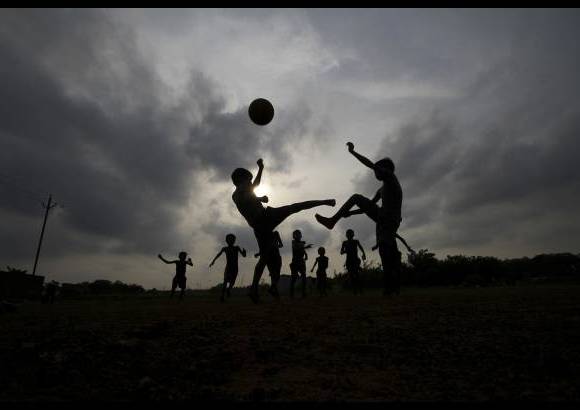 AP - Mientras los aficionados al fútbol de todo el mundo se están preparando para ver la Copa Mundial de fútbol, que se inaugura el 12 de junio, niños indios juegan al fútbol en un parque en Bhubaneswar, India.
