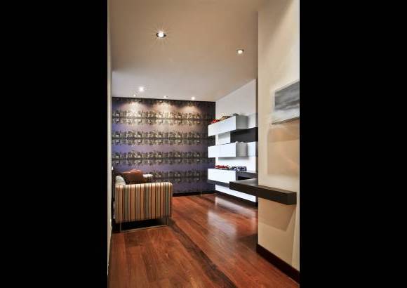 Foto Juan Fernando Cano - En el estudio-oficina, la iluminación destaca el paisaje urbano del papel de colgadura. La madera roble negro contrasta con los muebles de poliuretano blanco.