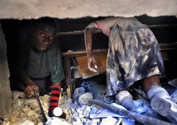 Reuters - Esta impactante imagen titulada Death of Innocence (muerte de la inocencia) y tomada por Carol Guzy del Washington Post, muestra a un hombre haitiano tratando de rescatar con vida a una profesora de las ruinas del colegio en el que trabajaba, mientras el cad&#225;ver de una colegiala yace tendido sobre su pupitre.