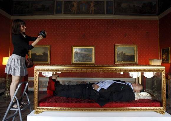 Foto Reuters - Los autores imaginan un Berlusconi con la corbata desabrochada; en la mano derecha, un ejemplar de la revista Una historia italiana, que el pol&#237;tico envi&#243; en su d&#237;a a las familias italianas y en el que publicitaba su trayectoria.