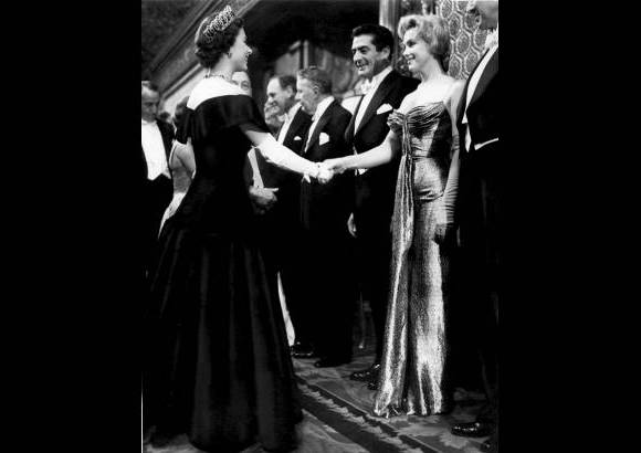 AP - Foto tomada el 10 de octubre de 1956 mientras Marilyn Monroe a la derecha, saluda a la reina Isabel II de Inglaterra.