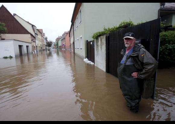 Reuters - Un residente y su propiedad inundada en una calle en la ciudad de Grimma, Alemania.