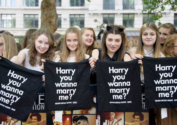 AP - Los fans del grupo One direction muestran mensajes de amor a Harry Styles en el estreno de la cinta This is us en Londres.