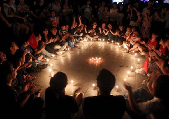 Reuters - Estudiantes en Hanoi, Vietnam, se reúnen alrededor de las velas durante La Hora del Planeta.