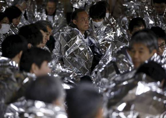 Reuters - Los participantes de un simulacro del desastre usaron mantas protectoras en el metro de Tokio.