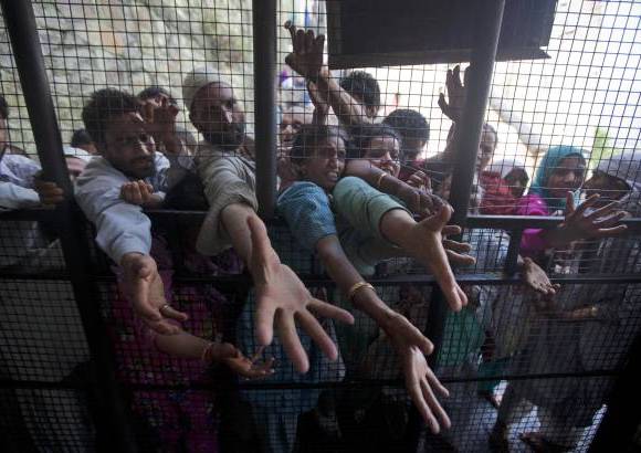 AP - Devotos musulmanes extienden sus manos para recibir ofertas en las afueras de un templo en el primer d&#237;a de Ramad&#225;n, en Srinagar, India.