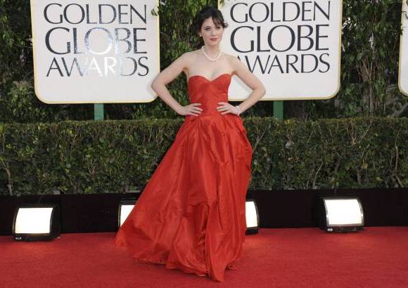 AP - Zooey Deschanel, que apostó por un Oscar de la Renta con escote corazón, collar, pulsera y pendientes de perlas y el pelo recogido en una coleta, buscaba un look socialité de los años 60, según comentó a los medios.