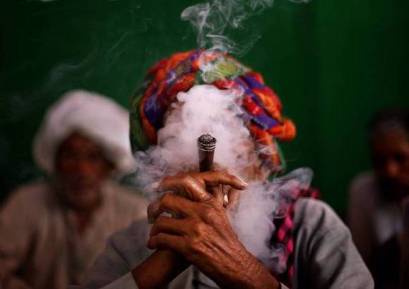 AP - Un aldeano indio fuma tabaco se une a otros manifestantes durante una manifestaci&#243;n exigiendo pensiones para los ciudadanos pobres de edad avanzada en Nueva Delhi, India.
