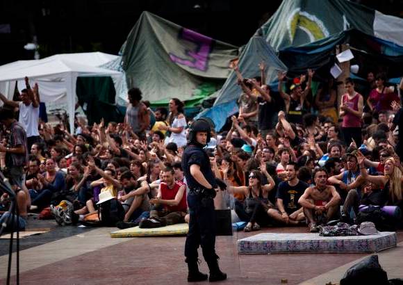 AP - Los iniciales momentos de tensión entre las fuerzas de seguridad y los indignados, que se negaron en todo momento a abandonar la plaza y que estuvieron apoyados por un millar de personas, derivaron en cargas policiales y disparos de pelotas de goma.
