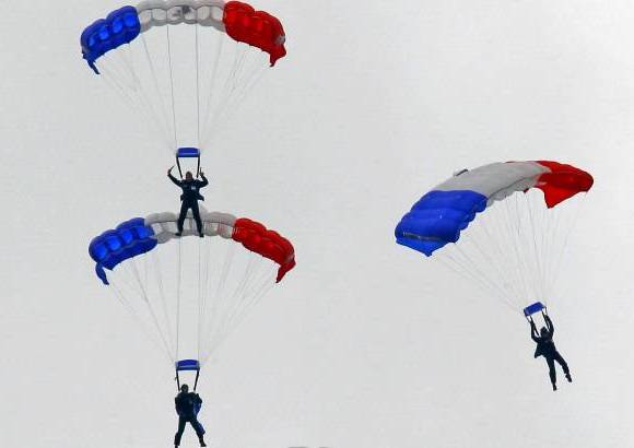 AP - Intensas ráfagas de viento desviaron a uno de los paracaidistas del lugar previsto de aterrizaje en el final del desfile hasta la Plaza de la Concordia.