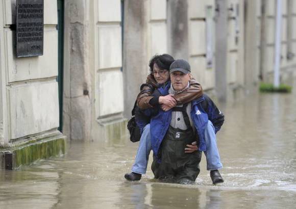 AP - Un voluntario lleva a una mujer de su lugar de trabajo fuera del casco antiguo de Passau, Alemania meridional.