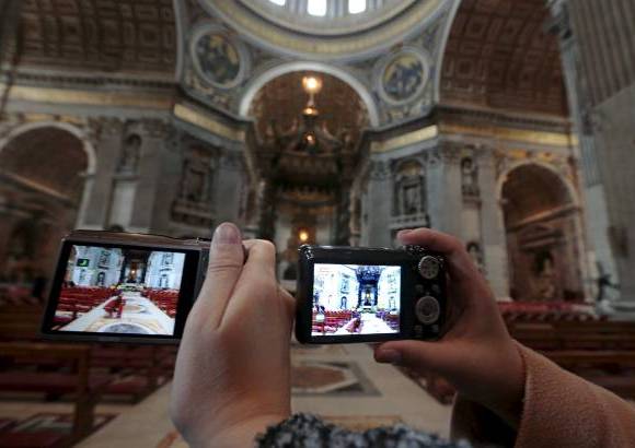 Reuters - Decenas de turistas toman fotos dentro de la Bas&#237;lica de San Pedro.