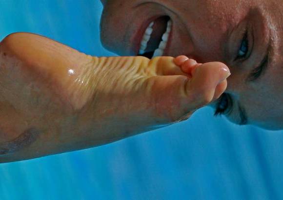 Henry Agudelo - Mientras dentro del agua de la piscina de nado sincronizado del Complejo Acuático, doce niñas, entre los 20 y los 28 años, practican de 7 de la mañana a la 1 de la tarde, afuera, tres entrenadoras (una canadiense, una bioelorusa y otra china), dos fisiólogos, un médico, una fisioterapeuta, un entrenador de acrobacias y una mánager, trabajan con sus computadores, filamadoras y toda clase de ayudas audiovisuales.