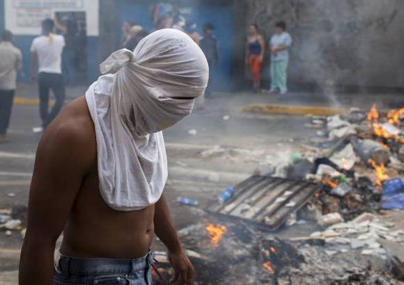 Federico Ríos Escobar - Los jóvenes, algunos con el rostro cubierto con franelas para protegerse de los gases lacrimógenos, se replegaron hacia una de las avenidas de la urbanización Altamira, en el este de la ciudad, donde formaron una barricada con restos de basura en medio de la vía que luego incendiaron.