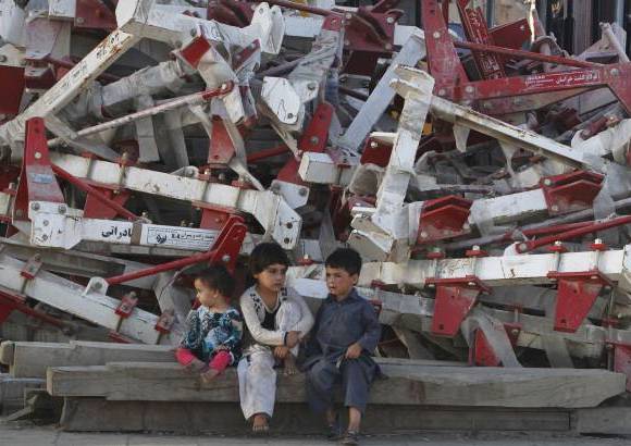 AP - Peque&#241;os esperan en un sitio de recolecci&#243;n de metal en Kabul, Afghanistan.