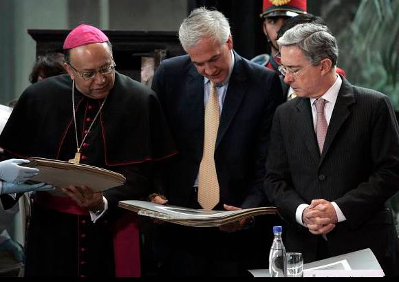 Reuters - Emocionados el presidente Álvaro Uribe, el cardenal Francisco Nieto y el alcalde Samuel Moreno ven los documentos que albergaba la urna centenaria.
