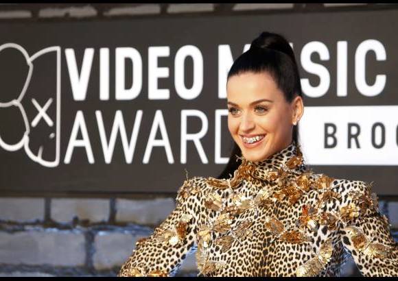 Reuters - La cantante Katy Perry muestar las joyas en sus dientes a la llegada a los Premios MTV.
