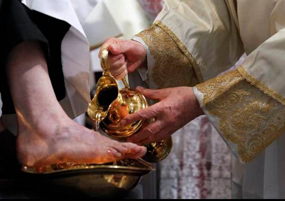 AP - Benedicto derram&#243; agua contenida en una jarra met&#225;lica dorada sobre los pies extendidos por cada sacerdote.