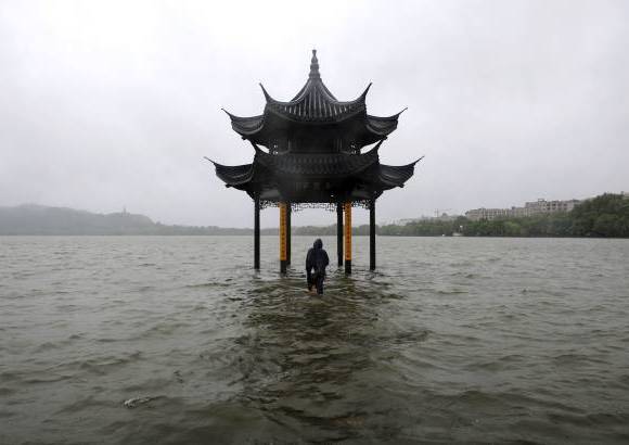 RE - Un hombre camina hacia un pabell&#243;n inundado por el desbordamiento del lago Oeste despu&#233;s que el tif&#243;n golpe&#243; la provincia de Zhejiang, China.