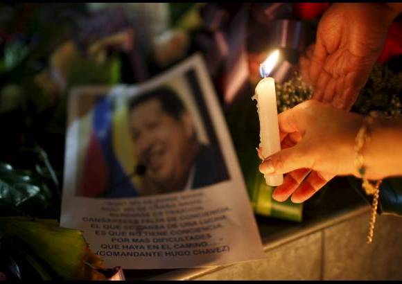 AP - Una mujer puso una vela frente a una imagen del presidente de Venezuela, Hugo Ch&#225;vez fuera de la embajada de Venezuela en La Paz, Bolivia.
