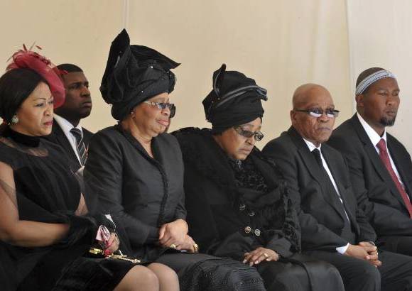 REUTERS - Una estela de luto formada por su viuda, Gra&#231;a Machel, su segunda esposa, Winnie Mandela, y el actual presidente de Sud&#225;frica, Jacob Zuma.
