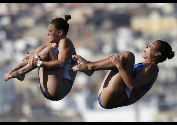 Reuters - Las clavadistas Cheyenne Cousineau y Samantha Bromberg de los Estados Unidos realizan una inmersión en sincronizados de mujeres plataforma 10 metros durante la final de los Campeonatos del Mundo de Natación en la piscina municipal de Montjuic en Barcelona.