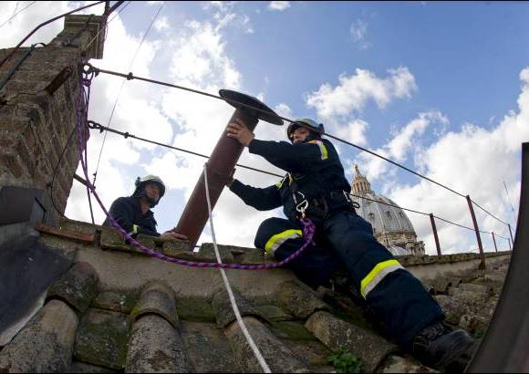 AP - Los bomberos instalan la parte superior de la chimenea de la Capilla Sixtina que se&#241;alar&#225; al mundo que un nuevo papa ha sido elegido.